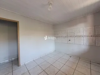 Ambiente interno de uma sala com piso de cerâmica e parede de destaque.