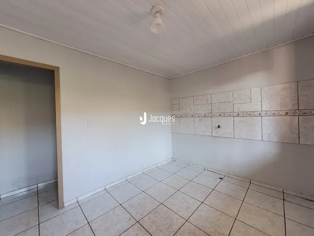 Ambiente interno de uma sala com piso de cerâmica e parede de destaque.