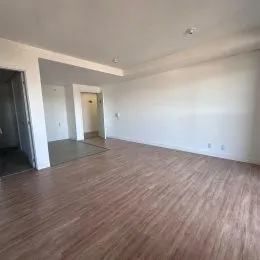 Vista interna de uma sala ampla com piso de madeira.