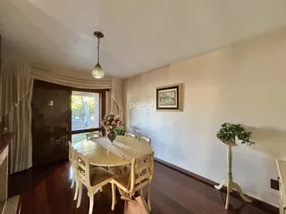 Sala de jantar com mesa de madeira e piso de madeira.