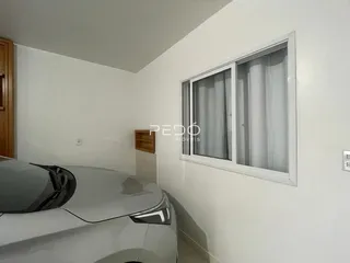 Uma vista interna de uma sala com uma grande janela.