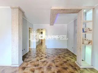 Hall de entrada com piso de ladrilhos marrons e paredes brancas.