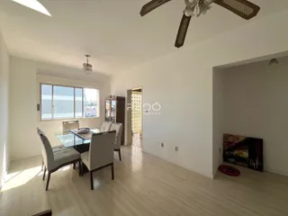Ambiente interno de uma sala de jantar com piso de madeira clara.