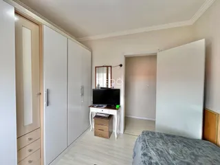 Quarto com armários embutidos e piso de madeira clara.