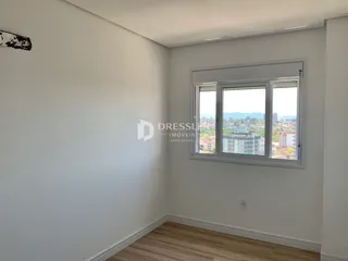 Interior de um cômodo com parede branca e piso de madeira.