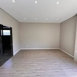 Foto de um ambiente interno amplo com paredes brancas e piso claro.