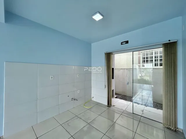 Interior de uma sala com paredes azuis claras e piso de cerâmica.