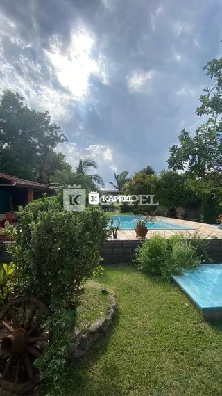 Vista externa de um jardim com gramado e piscina em Lajeado.