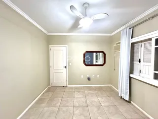 Vista interna de uma sala com piso de cerâmica e paredes claras.
