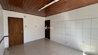 Interior de uma sala com piso de cerâmica e teto de madeira.