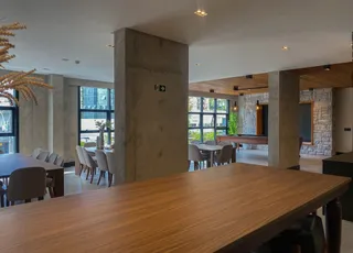 Interior de uma sala de jantar com colunas de concreto expostas.
