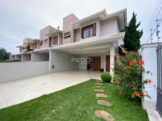 Fachada de uma casa em Lajeado, Brasil, com jardim e área pavimentada na frente.