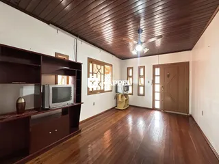 Esta é uma sala de estar com piso de madeira e forro de madeira.