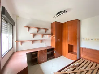 Quarto com armários de madeira e cabeceira de madeira.