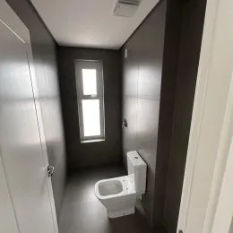 Corredor interno com um vaso sanitário branco visível.