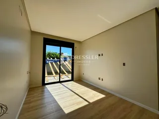 Sala de estar com porta de vidro abrindo para o quintal.