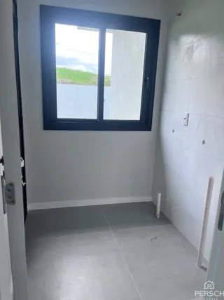 Foto de um corredor interno com uma grande janela de esquadria preta.
