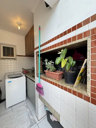 Interior de uma área de serviço com revestimento de tijolo aparente.