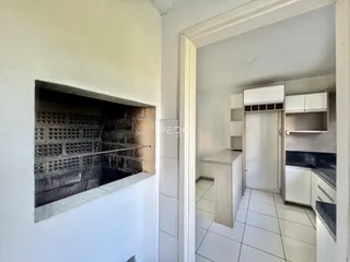 Vista de um interior com uma parede de tijolos expostos e uma porta de passagem.