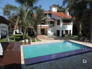 Foto da fachada de uma casa com piscina e jardim em Lajeado.