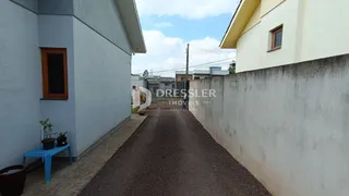 Vista externa de um imóvel com paredes laterais e um caminho de terra.