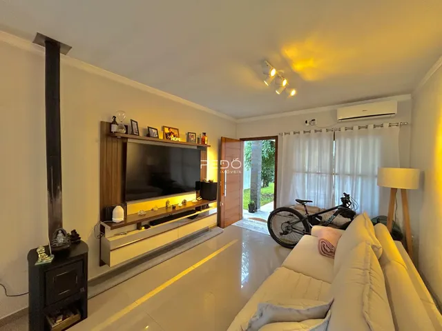 Sala de estar com sofá e painel de TV em um apartamento.