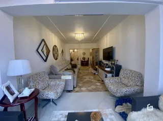 Sala de estar com sofá e poltronas decorativas em um imóvel.