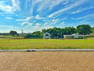 Vista externa de uma propriedade com gramado e área verde.