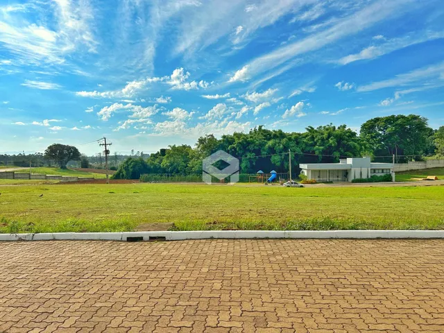 Vista externa de uma propriedade com gramado e área verde.