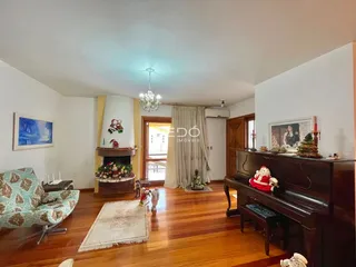 Sala de estar com piso de madeira e lareira em um imóvel no Brasil.