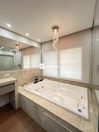 Banheiro com banheira branca e bancada de mármore.