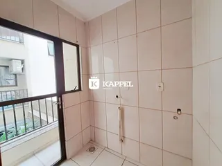 Interior de um banheiro com revestimento de azulejos e acesso a uma varanda.