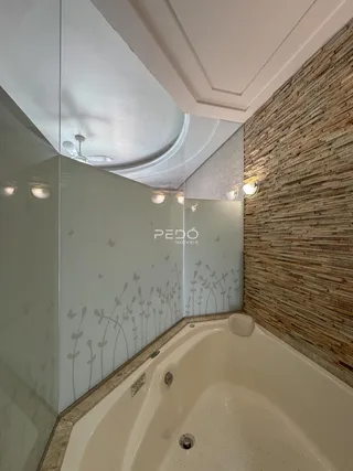 Foto de um banheiro com banheira e revestimento de parede texturizado.