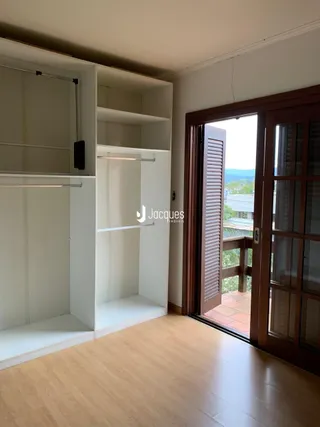 Uma vista interna de um ambiente com armários embutidos e piso de madeira.