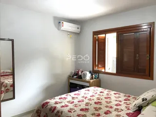 Quarto interno com cama e janela em um imóvel no Brasil.