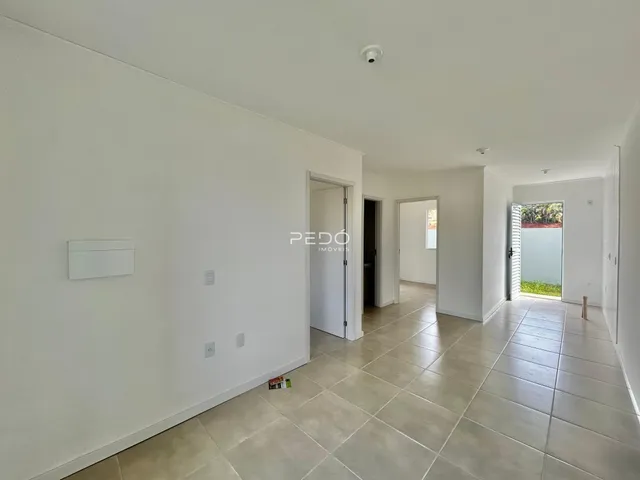 Hall de entrada com piso de cerâmica claro.