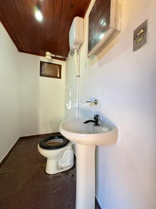Interior de um corredor com piso de cerâmica e um vaso sanitário branco.