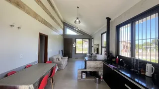 Interior de uma sala de jantar com grandes janelas em um imóvel no Brasil.