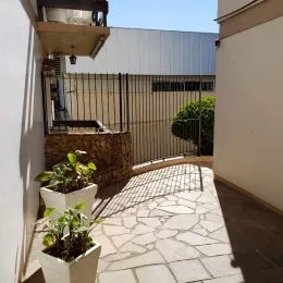 Área externa com piso de pedra e plantas em um imóvel.