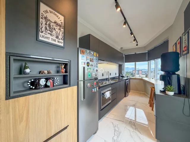 Vista da cozinha moderna com armários escuros e piso de mármore claro.