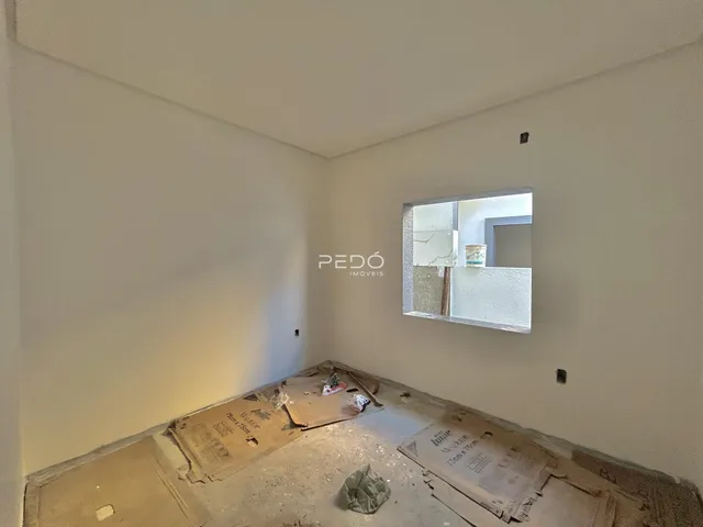 Quarto em reforma com piso exposto e materiais de construção no chão.
