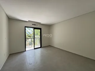 Ambiente interno de uma sala com piso de concreto e porta de vidro.
