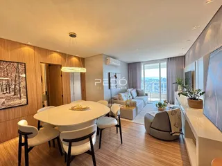Sala de estar e jantar com piso de madeira clara e vista da cidade.