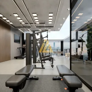 Foto de uma área comum interna com equipamentos de ginástica e aparelhos de musculação.