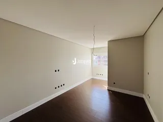 Corredor interno de uma residência com piso de madeira escura.
