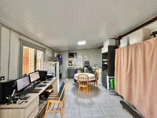 Ambiente interno de uma sala de estar com piso de cerâmica e móveis de madeira.