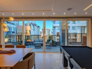 Sala de jantar com portas de vidro que dão para o exterior.