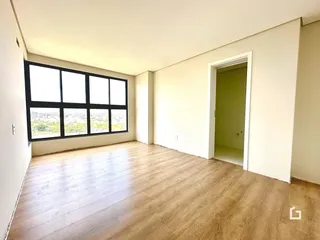 Sala de estar com grande janela e piso de madeira clara.