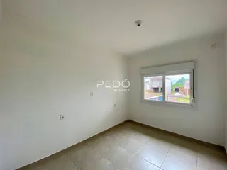 Ambiente interno de uma sala com piso de cerâmica e janela para o exterior.