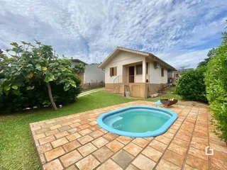 Vista da fachada de uma casa com piscina e jardim.